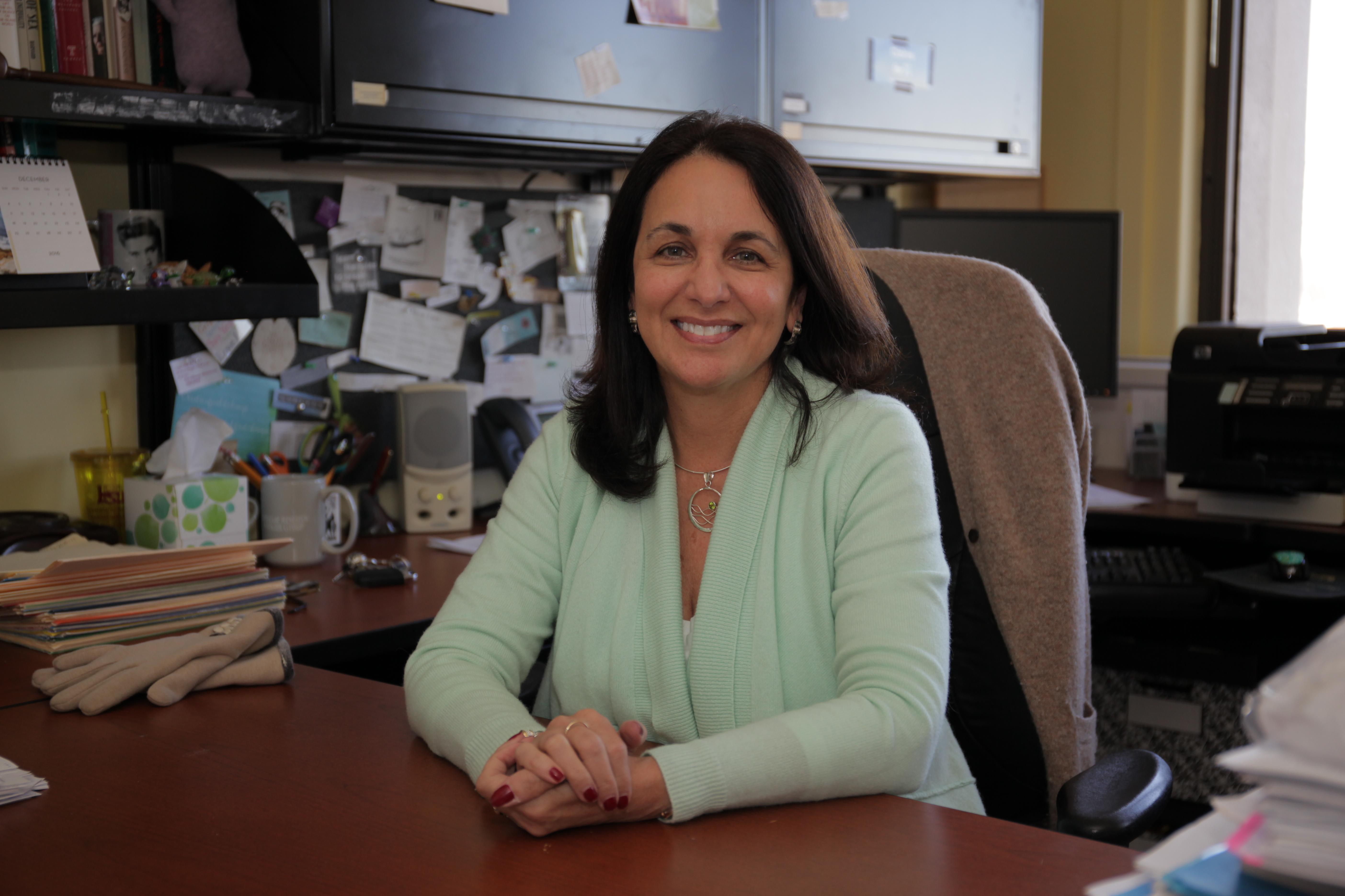 Claire Renzetti sits at a desk. 